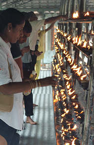 Ludzie zapalajcy wieczki w wityni Buddhy w Kandy, gdzie znajduje si wita relikwia- zb Buddhy